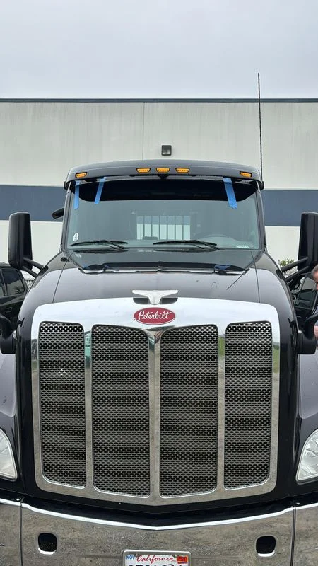Two Del Mar Auto Glass technicians replacing a commercial truck windshield